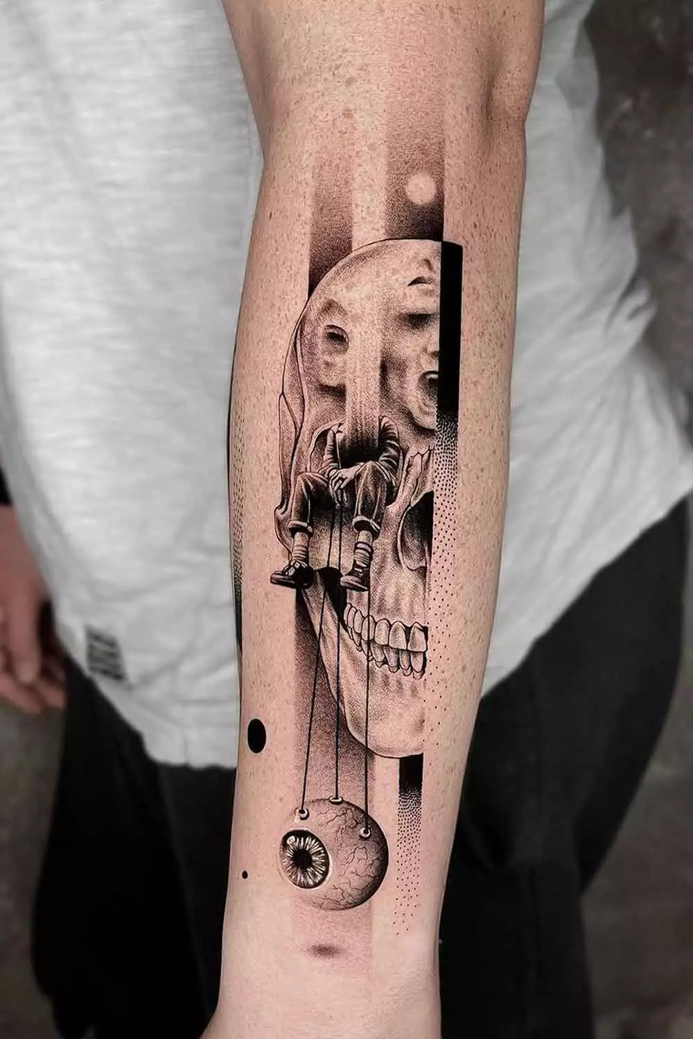 Surreal blackwork forearm tattoo — skull and figure study