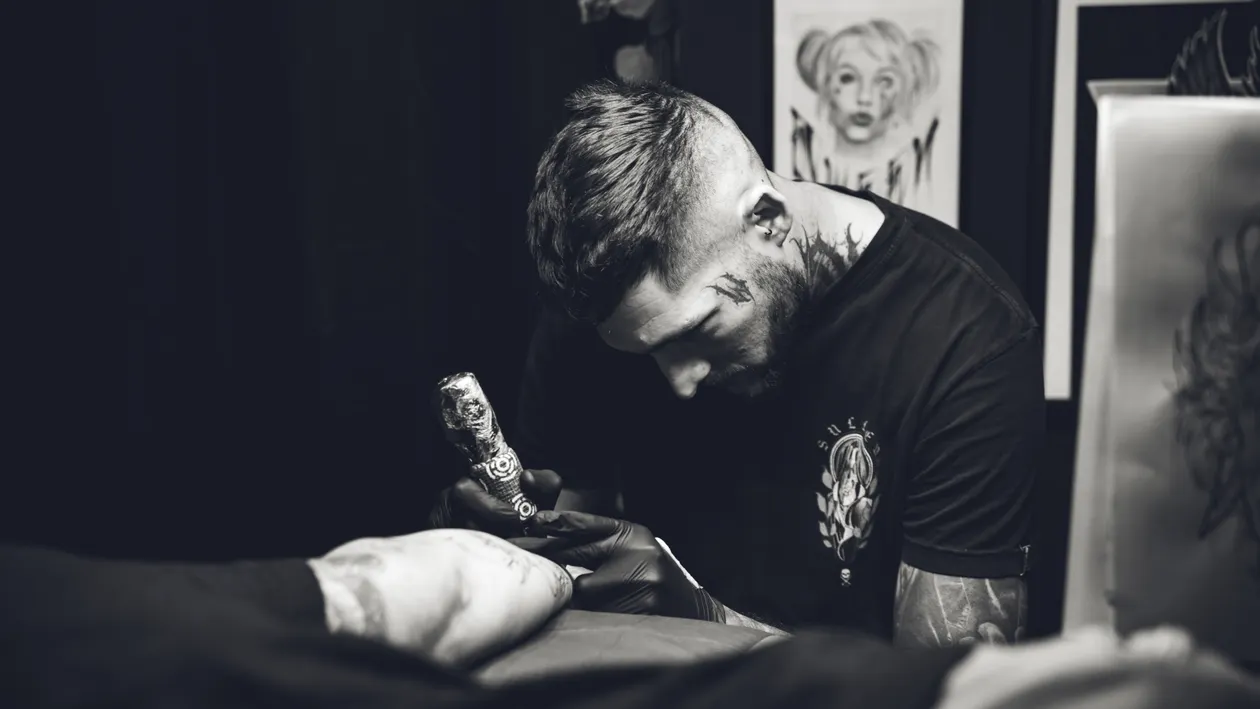 Artist tattooing in a dark studio